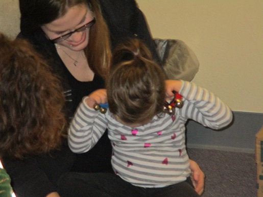 A blind child is investigating the sound makers with her ears